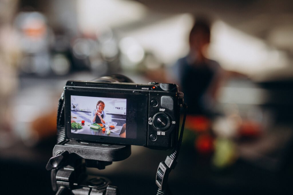 young woman videoblogger cooking at the kitchen and filming