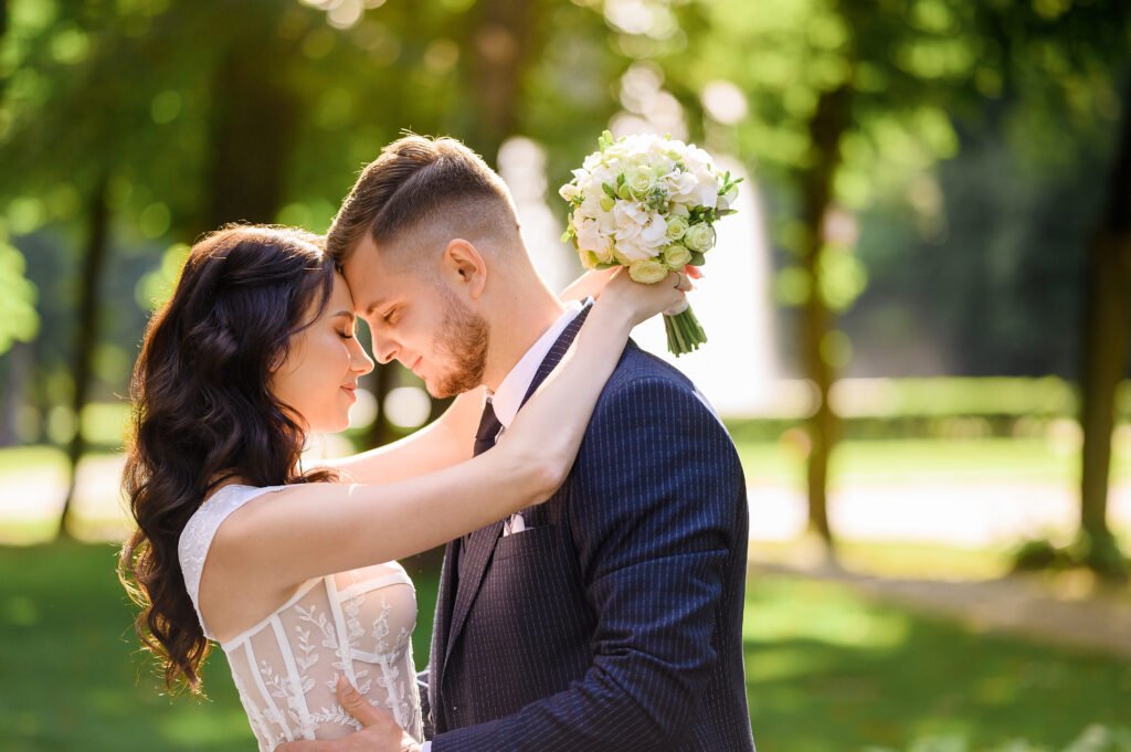 side view happy woman with curly hair beautiful makeup wearing fashionable dress hugging groom by neck